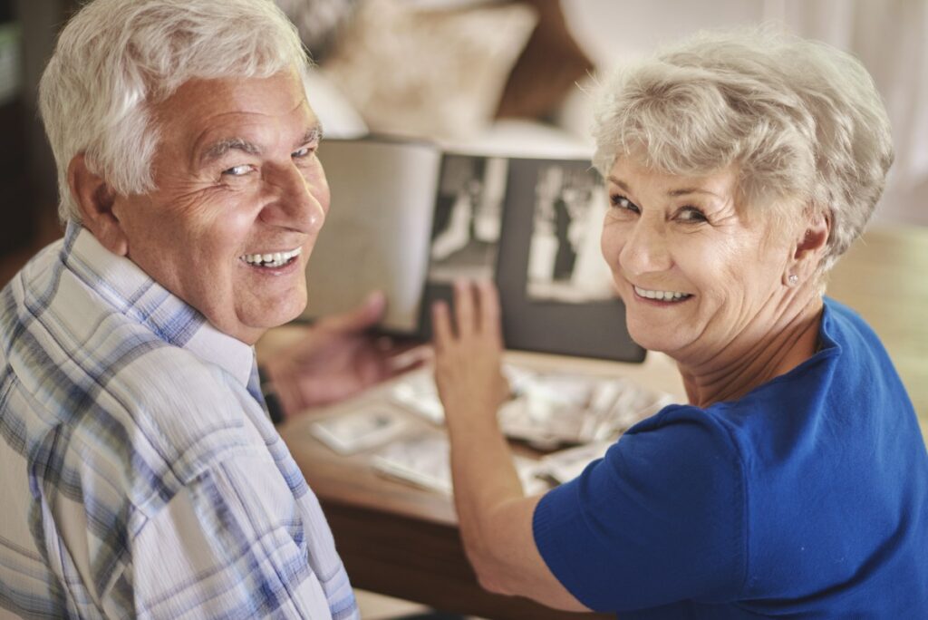 storyblocks-cheerful-senior-couple-browsing-album-with-their-photographs_Swf5FvZKcG